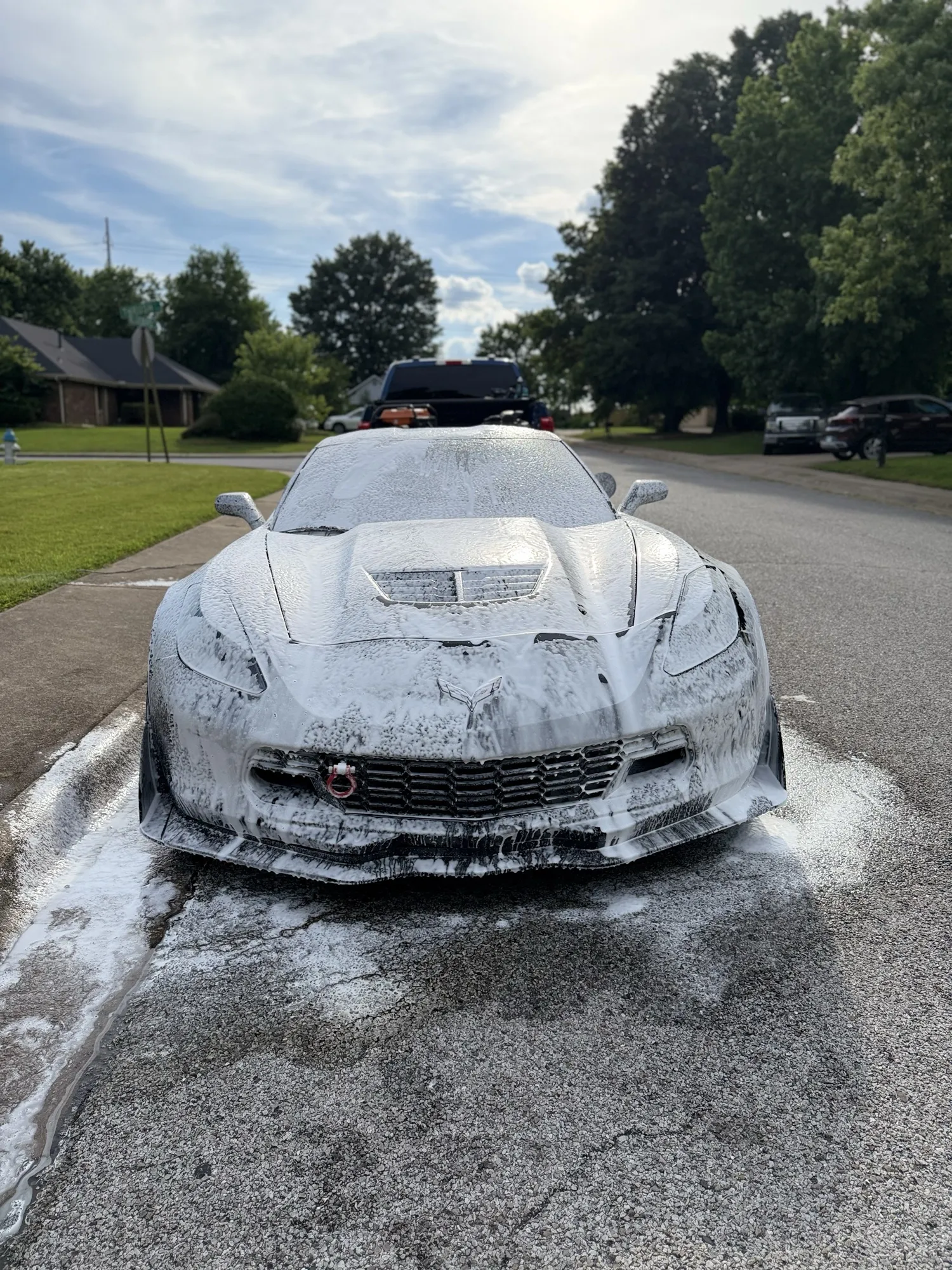 A foam-covered Corvette being detailed